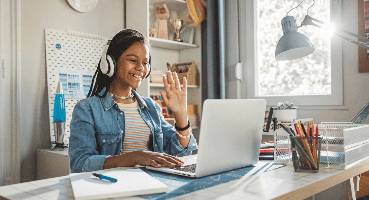 Student raises her hand during virtual class, showing that she is engaged.