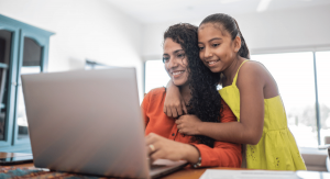A mother and daughter explore school choice options on a laptop.
